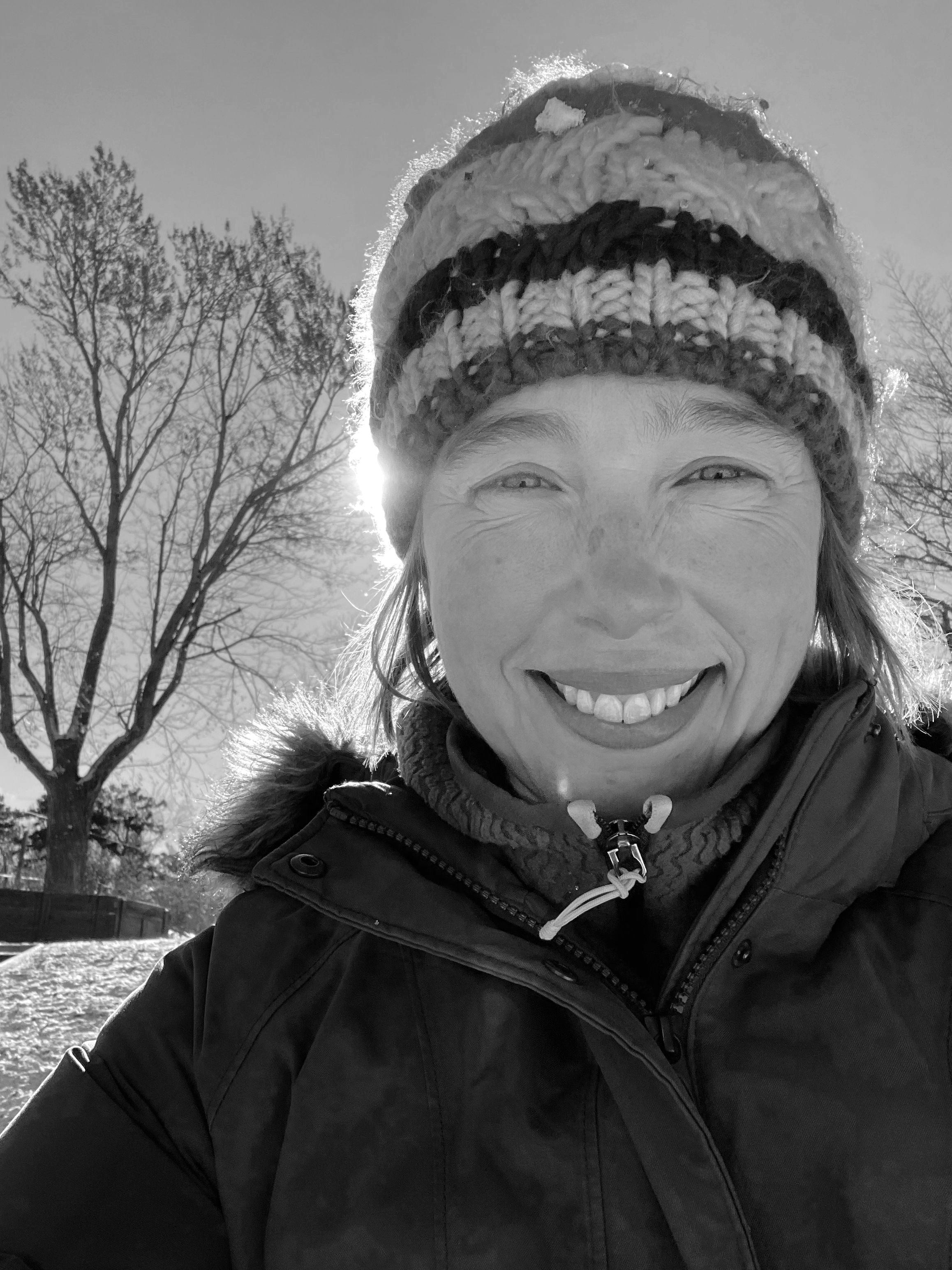 Emily Watson Purewal smiling outdoors in a knit hat and winter coat